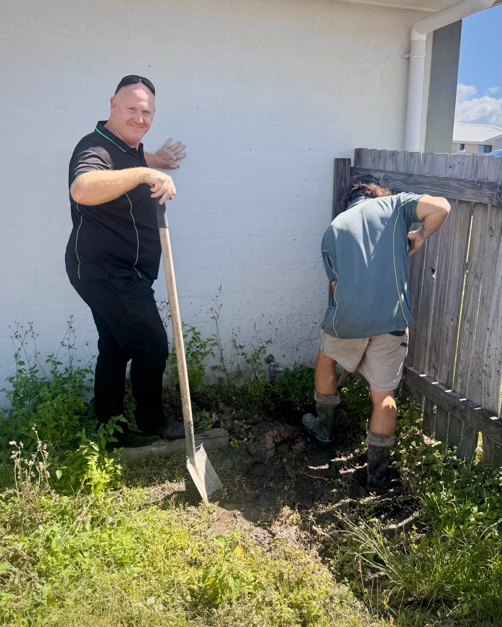 Our Property Management Lead Troy Gesler on a shovel assisting a plumber
